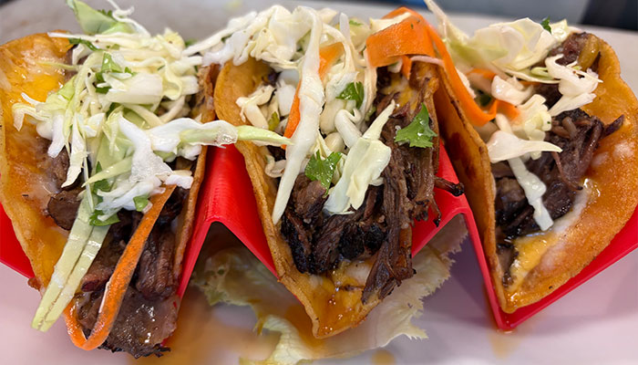 Three beef tacos with shredded cabbage in crispy tortillas from the Cafe Catron menu.